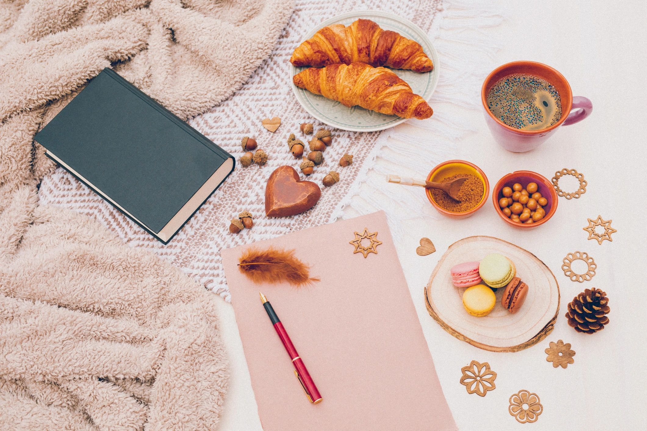 Coffee, book, pastry, and blank paper with fountain pen from above