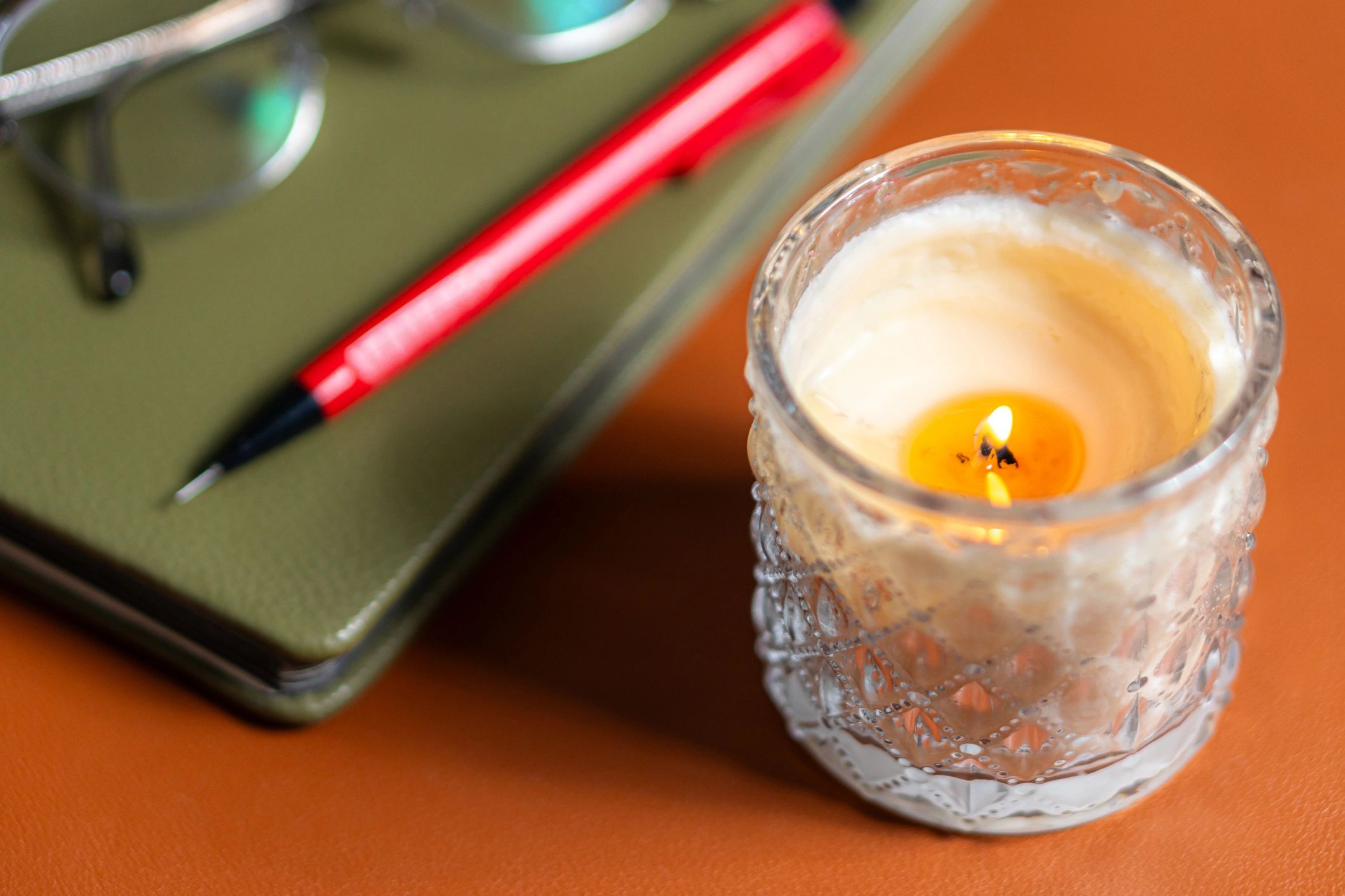 Quiet workspace with candle and notebook for ambient listening